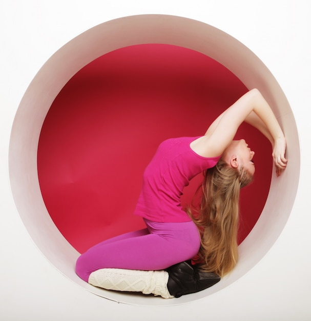 Sporty woman posing in pink circle