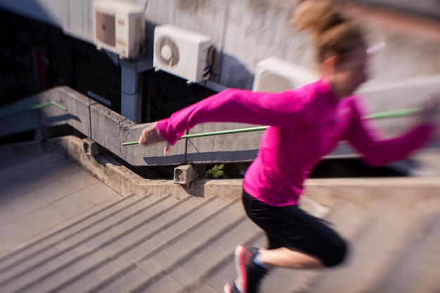 sporty woman running onsteps at early morning jogging