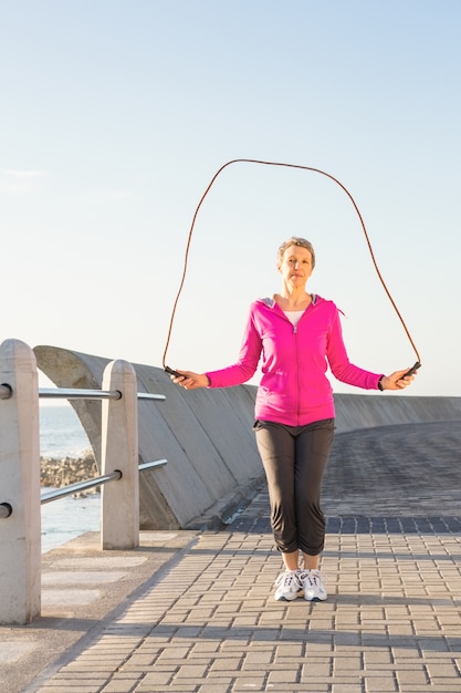 Photo sporty woman skipping at promenade