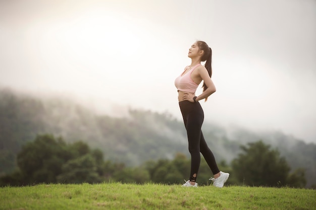 Una donna sportiva in abiti sportivi si esercita nel giardino di fronte a casa sua