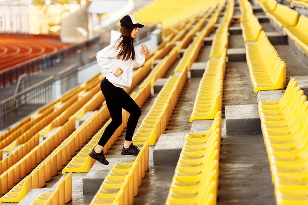 夏の階段のスタジアムでスポーティな女性エクササイズをしている女性