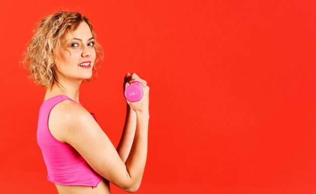 Спортивная женщина тренируется с гантелями, спортивная фитнес-девушка в спортивной одежде делает тренировку с гантелями