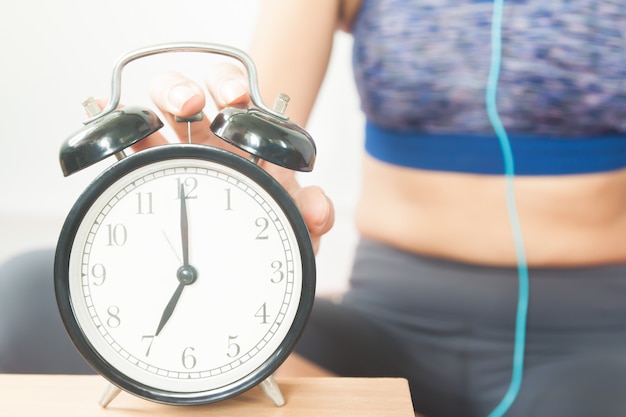 Sporty woman with alarm clock