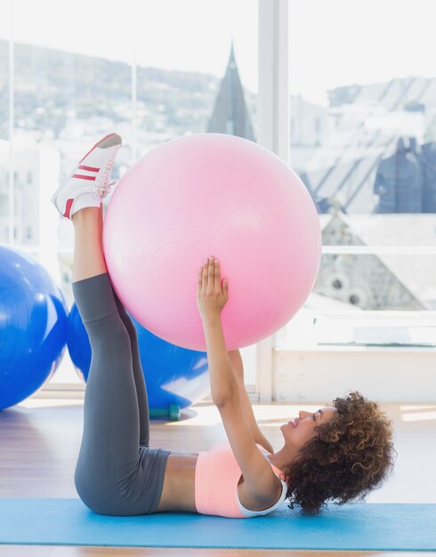 Sporty woman with exercise ball in fitness studio