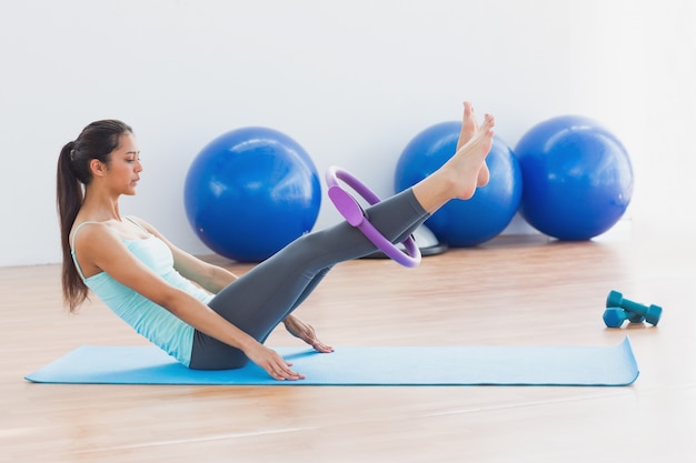 Sporty woman with exercising ring in fitness studio