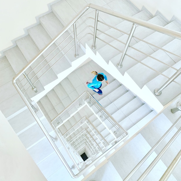 Sporty woman working out running up stairs indoors for morning
workout