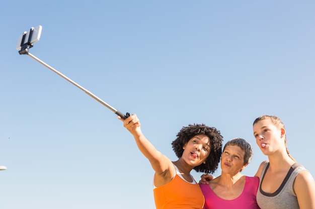 Foto donne sportive che posano e prendono autoscatti con il selfiestick