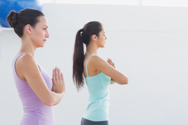 Sporty women with joined hands in fitness studio