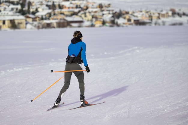 クロスカントリースキーを練習するスポーティな若い女性