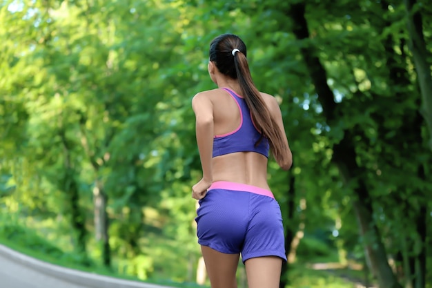 公園で走っているスポーティな若い女性