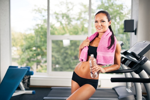 Sporty young woman standing in gym 