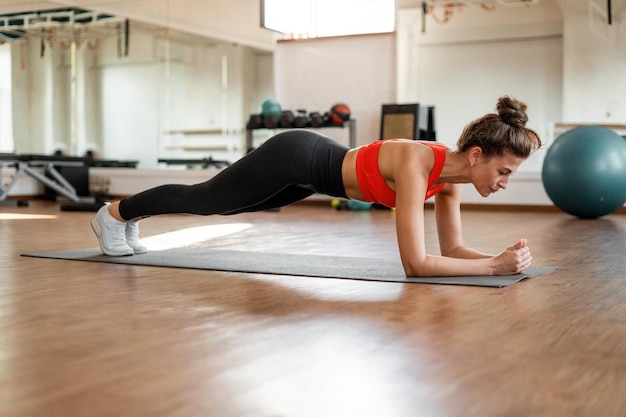 A sporty young woman trains in a fitness club uses sports equipment aerobics and pilates