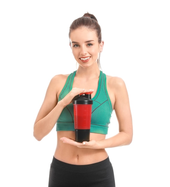 Sporty young woman with protein shake on white