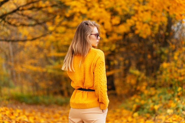 Sporty young woman with slender sexy legs in fashionable skirt\
in stylish white sneakers walks on street on sunny day. fashion\
women\'s shoes. summer style. closeup of female legs in sports\
footwear.