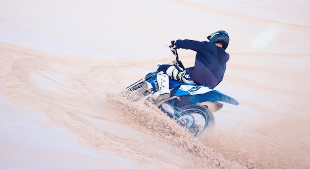 Sportzandduinen en atleet op motor voor actie adrenaline en vaardigheidstraining voor uitdaging Fitness woestijn en man biker oefenen voor racecompetitie of prestatie-avontuur tijdens een rally