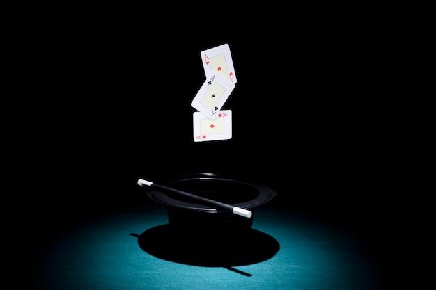 Photo spot light over the top hat with three aces playing card