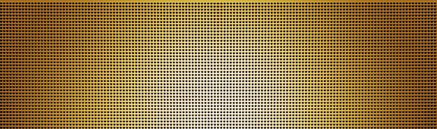 Spot lit perforated gplden metal plate. Metal background close-up