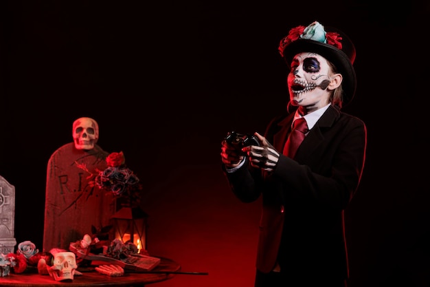 Sppoky model met santa muerte make-up die videogames speelt in de studio, gekleed in halloween-kostuum van Mexicaanse vakantietraditie. Controller gebruiken om op gameconsole te spelen, dios de los muertos.