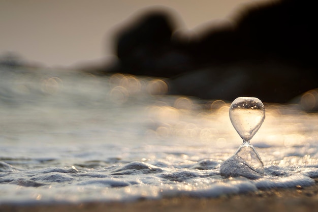 Sprankelende zandloper met fascinerende bubbelvervaging zeerimpeling op de achtergrond bij zonsondergang