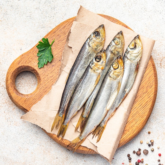Килька копченая мелкая рыба сельдь соленые морепродукты еда закуска на столе копией пространства