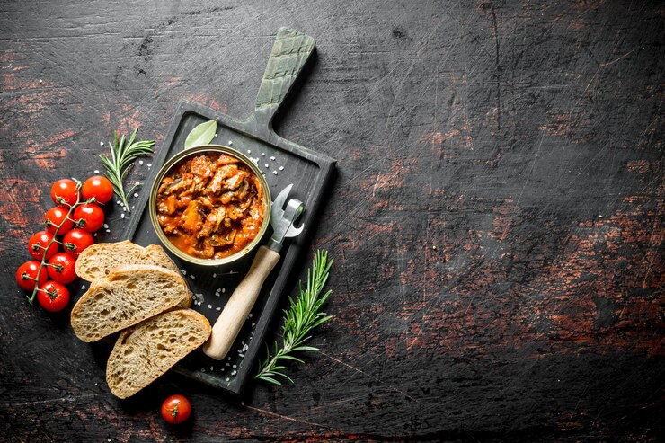 Photo sprat in tomato sauce with bread and tomatoes on the cutting board