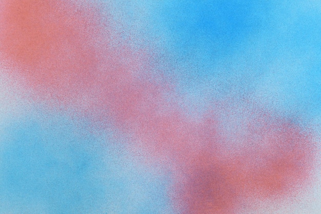 Spray paint red and blue on a white paper background