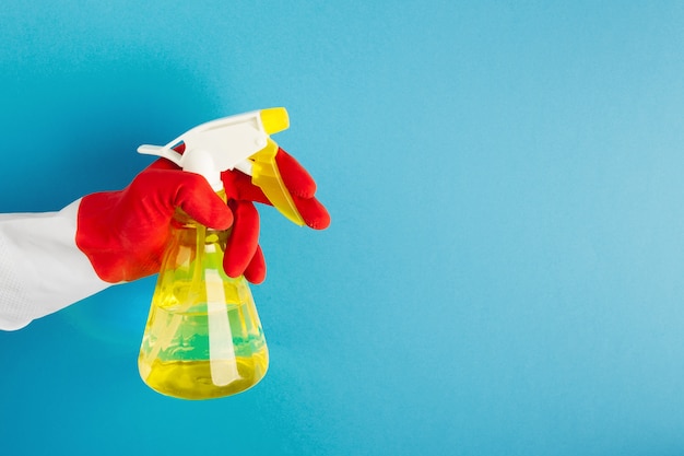 Foto spruzzare con il detergente in mano indossando un guanto