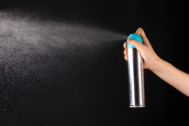 Sprayed air freshener in hand on grey background