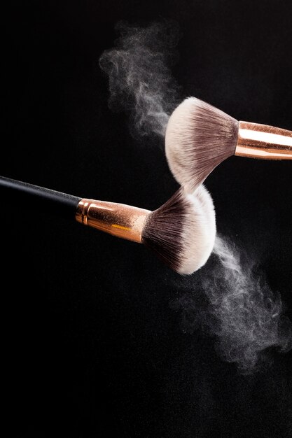 Sprayed with a professional cosmetic brush powder powder, decorative cosmetics in the form of powder with a brush for its application, powder scattered together with a cosmetic brush