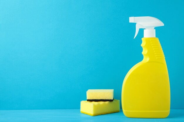 sprayer with sponges for cleaning on blue background.