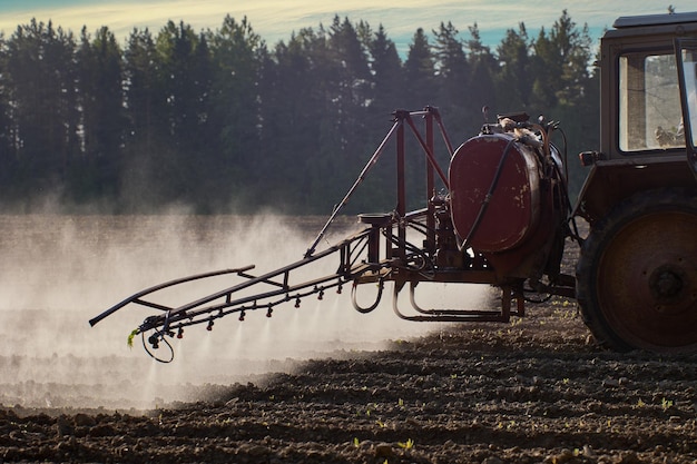 Photo spraying crops with chemicals such as pesticides or herbicides using sprayer mounted on wheeled