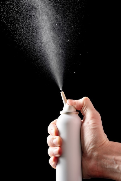 Foto spruzzo spray con acqua di mare salata per il trattamento della rinite isolata su sfondo nero