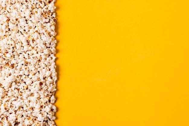 Spread popcorns on yellow background