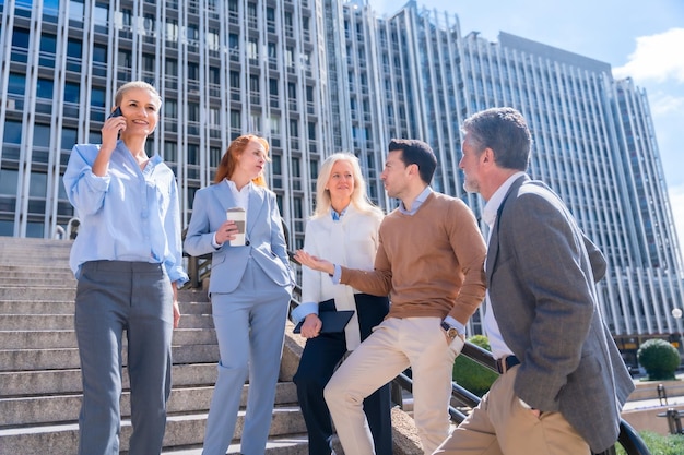 Spreken in een ontspannen moment tijdens de rust Groep collega's buiten in een kantoorruimte