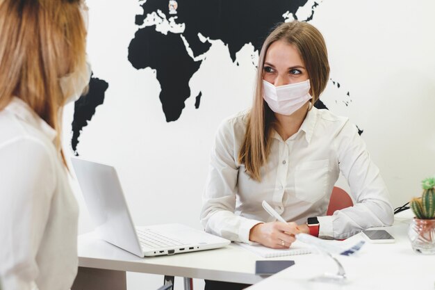 Foto spreken met gezichtsmasker in het reisbureau