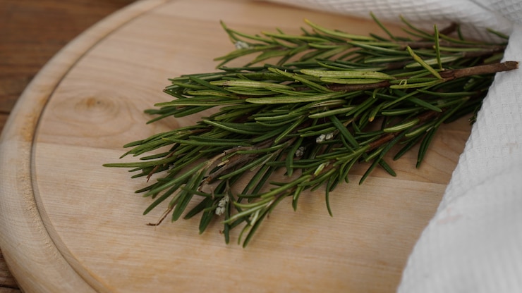 Photo 절단에 대 한 나무 보드에 로즈마리의 sprigs. 소박한 스타일. 기미
