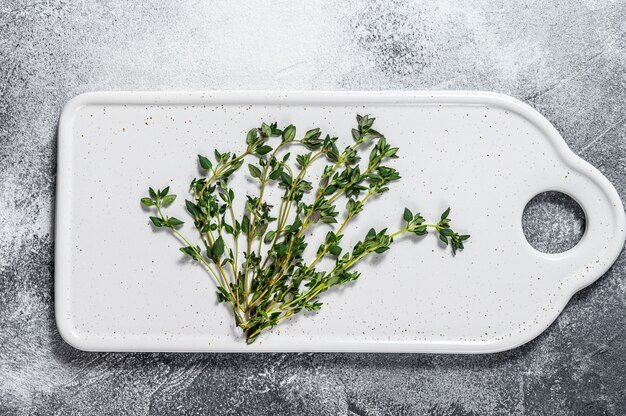 Sprigs of thyme on a white cutting Board. 