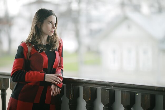 Spring adult girl outdoor / march in scotland, a girl in a plaid poses in the park