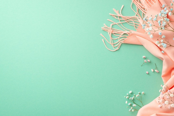 Photo spring aesthetic concept top view photo of gypsophila flowers and pink soft scarf on isolated teal background with copyspace