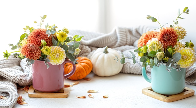 Spring background with flower arrangement and pumpkins on a blurred background.