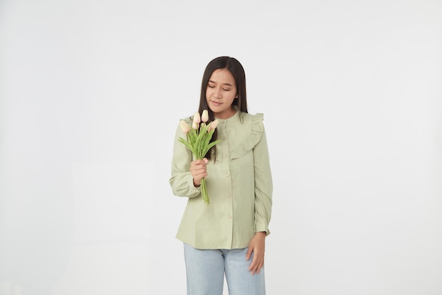 Весна Красивая веселая девушка улыбается и держит букет цветов тюльпана. Молодая счастливая азиатская женщина.
