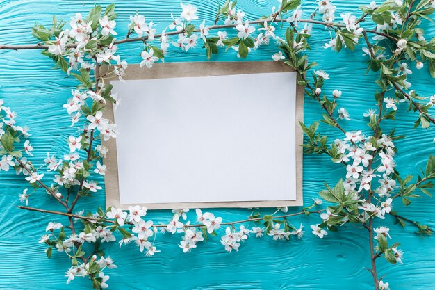 spring blossoms and greetind card on wooden background