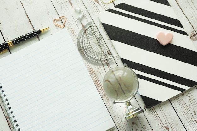 Spring book, black and white notebook, pen, paper clips and glass globe