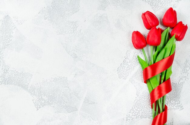 Spring bouquet of red tulips with ribbon.