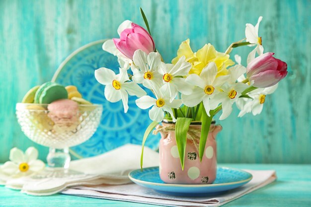 Spring bouquet in vase on color wooden background