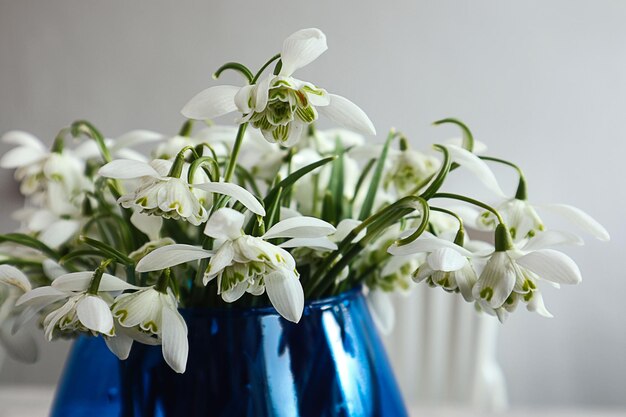 写真 春の花束青い花瓶のクローズアップのスノードロップの花束