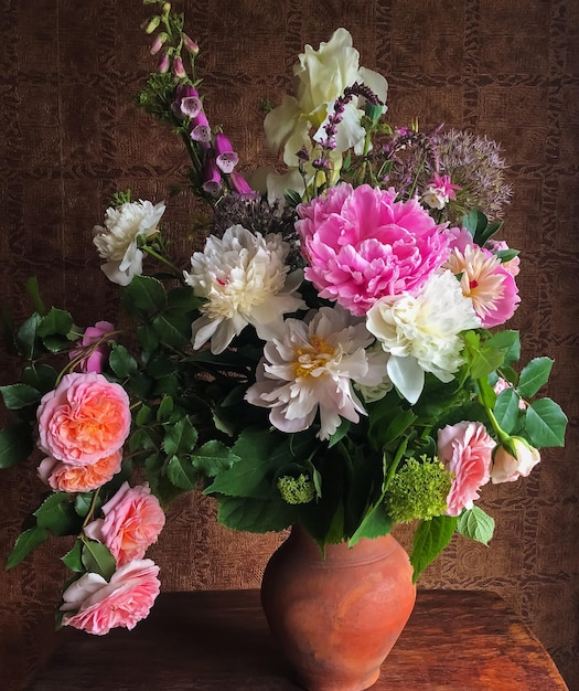 Spring bouquets of farm flowers in the interior Floristics  art of flowers arrangements Romantic bouquet with roses peonies foxglove alliums irises hydrangea sage