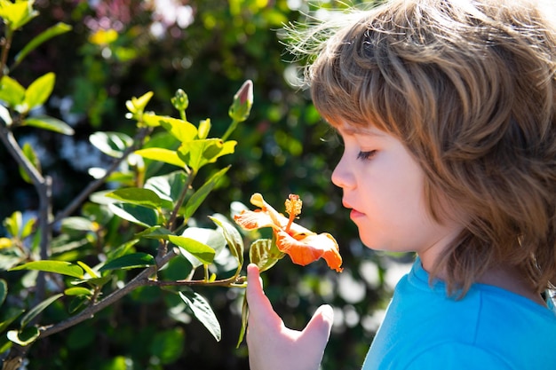 Spring boy in nature park Kid with flower outdoor Blossom garden