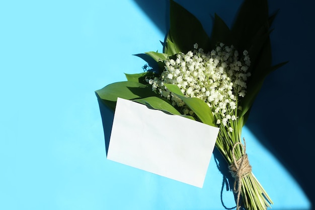 Spring card with lilies of the valley on blue background