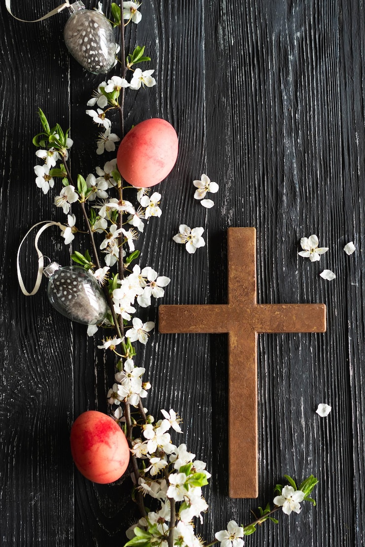 Photo spring cherry blossoms and easter eggs and cross on old wooden background